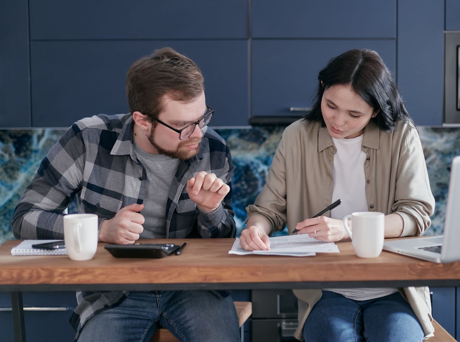 Couple qui remplit des formulaires à la table de la cuisine