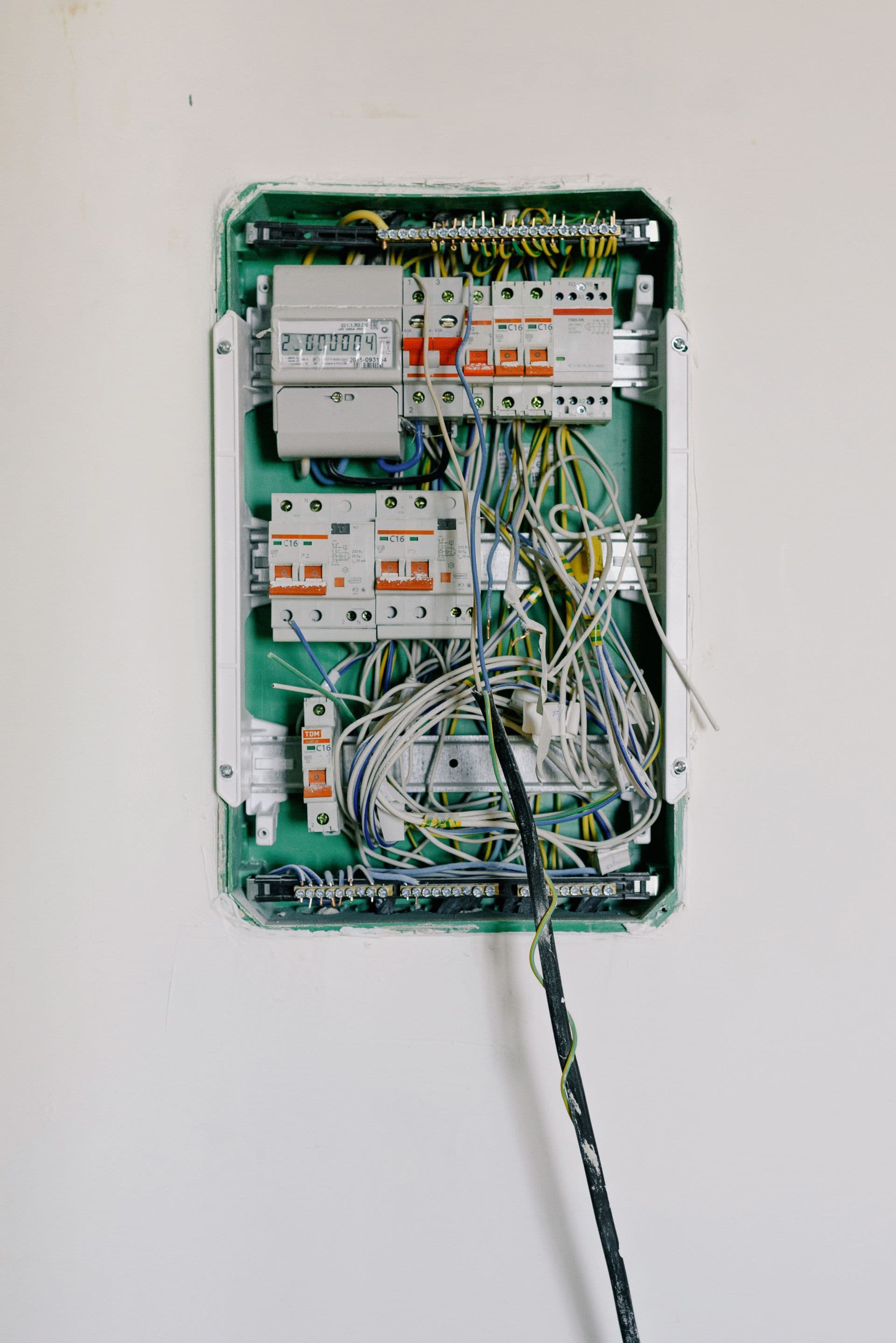 Tableau électrique ouvert, disjoncteurs et câblage apparents
