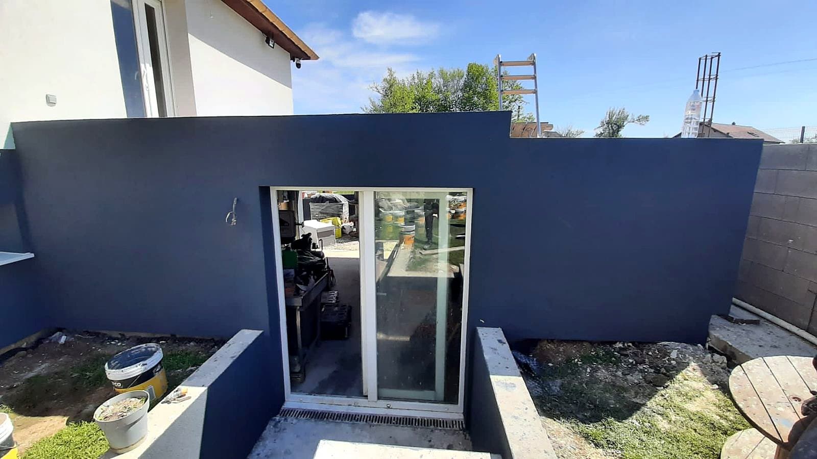 Façade isolée par l'extérieur, enduit gris anthracite autour d'une baie vitrée