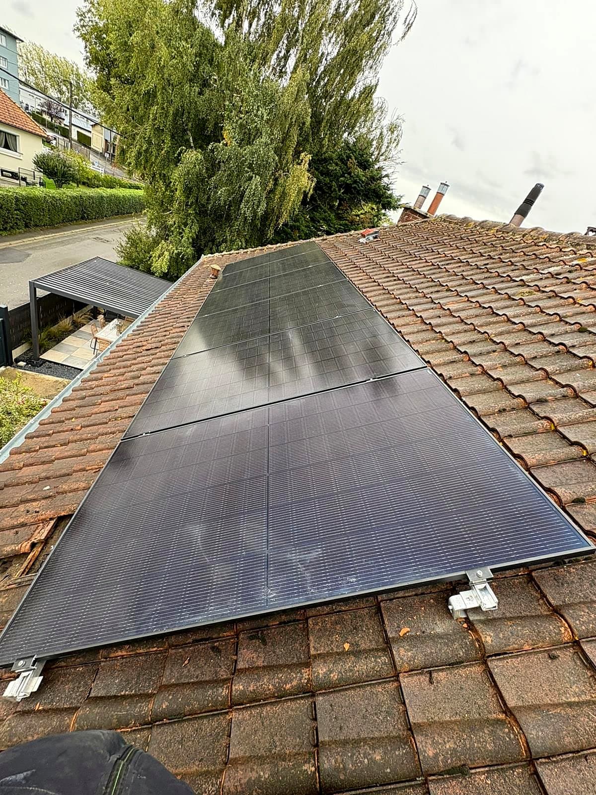 Panneaux photovoltaïques noirs sur un pan de toiture en tuiles