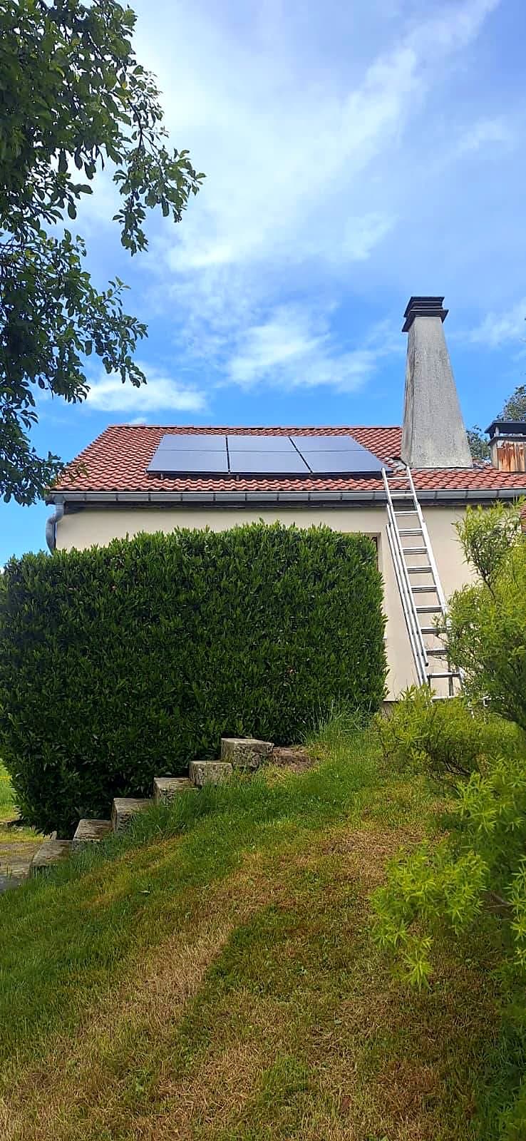 Panneaux photovoltaïques sur la toiture d'une maison au jardin en pente