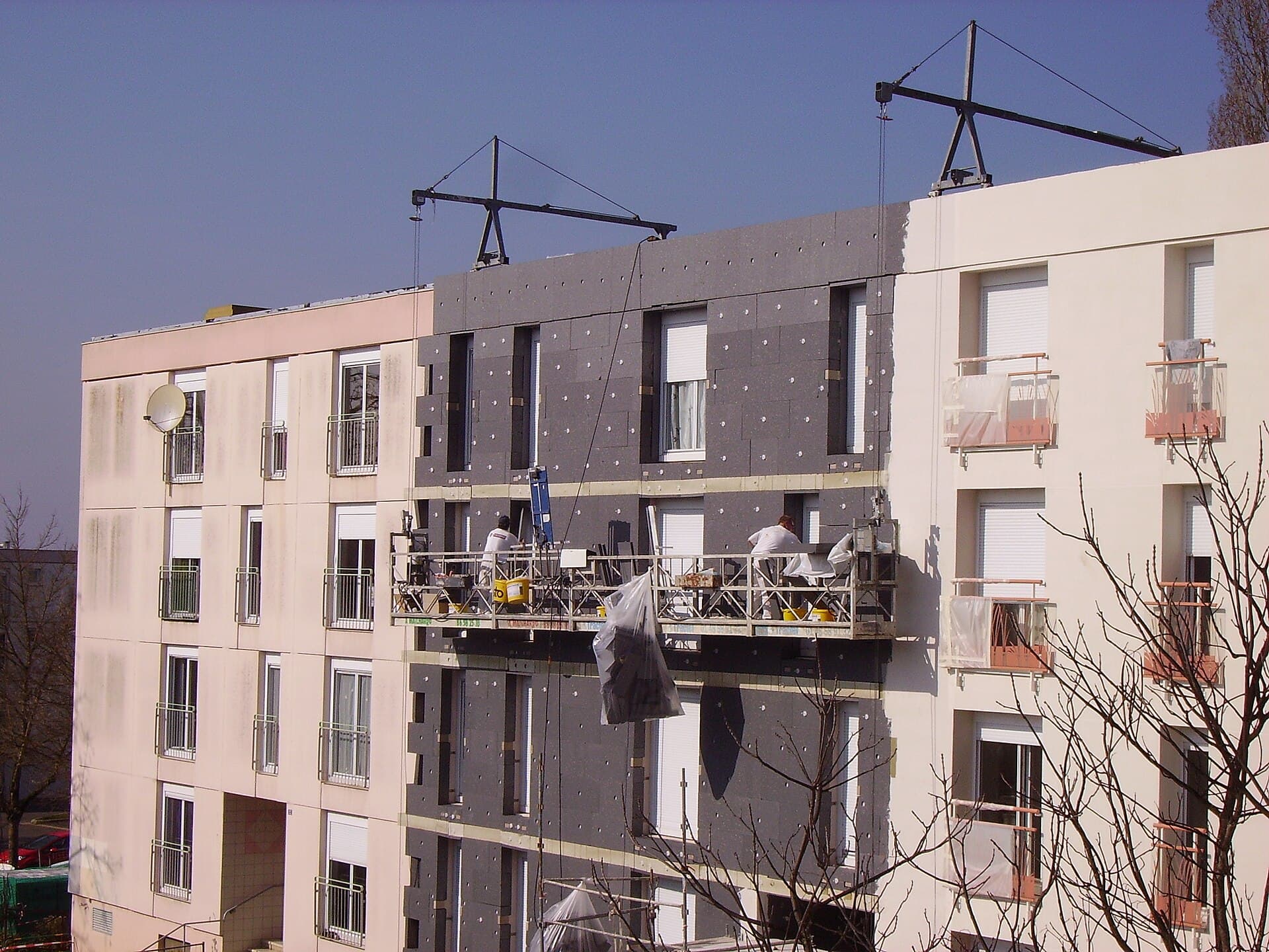 Façade d'immeuble en cours d'isolation par l'extérieur, panneaux isolants posés
